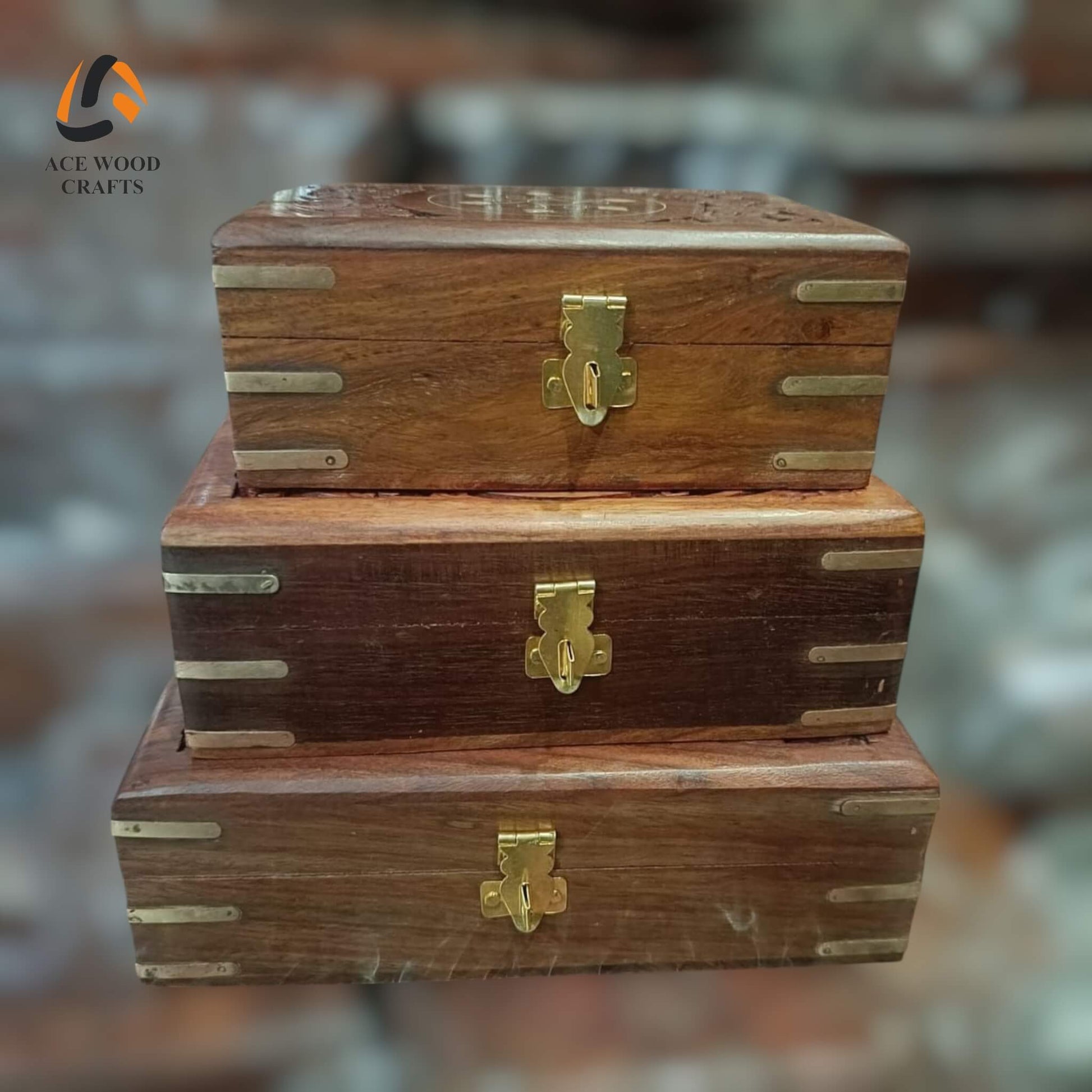Front view of stacked wooden storage boxes with brass corners and gold-colored locking latches
