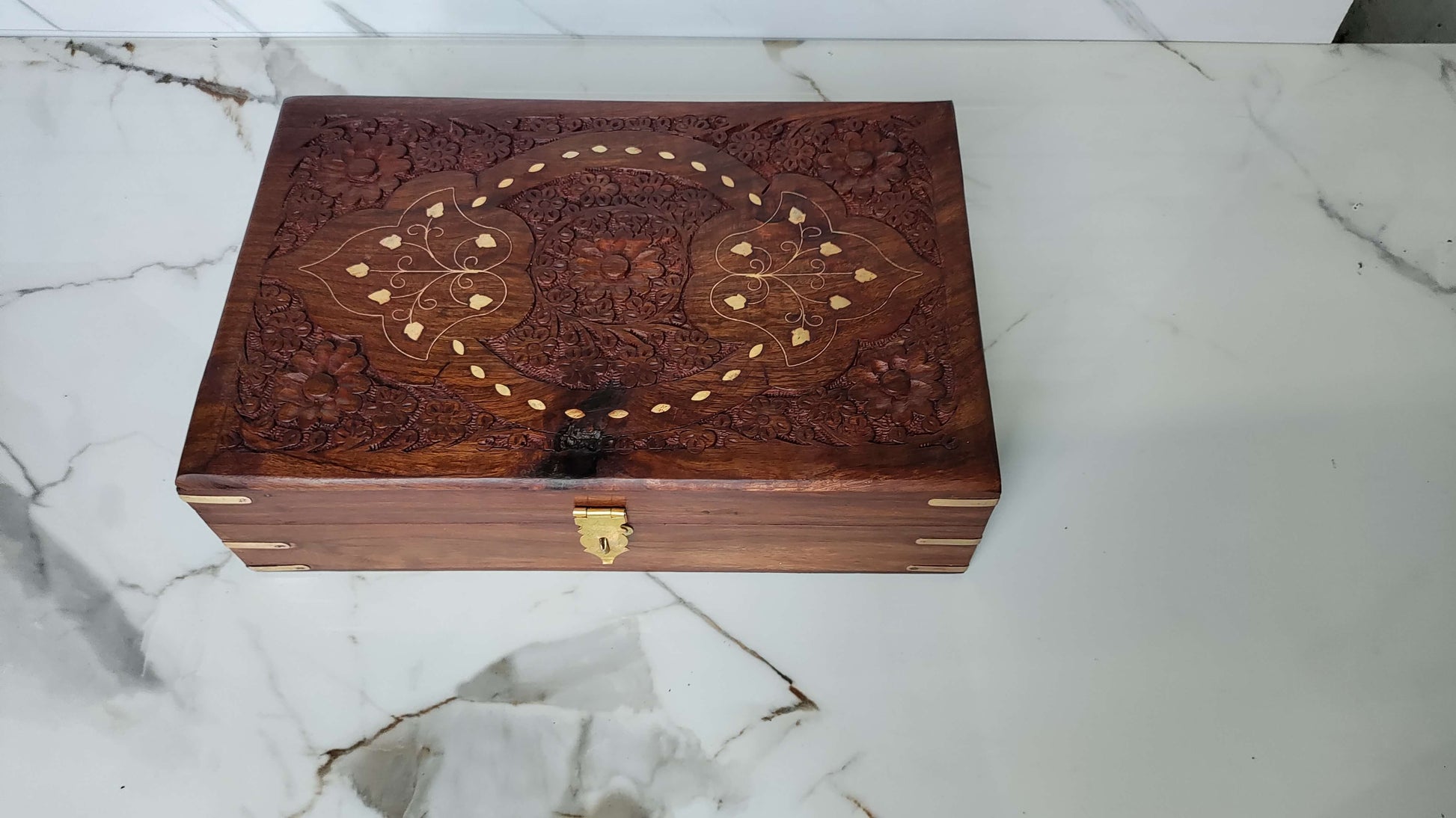 Front view of the box highlighting the brass latch and reinforced brass corner brackets.