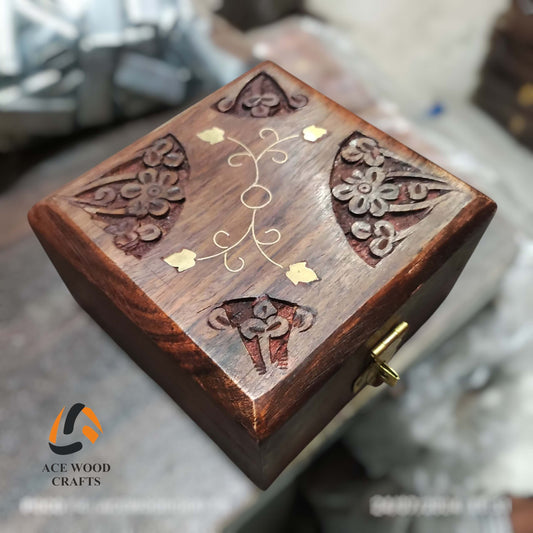 Angled view of antique-style wooden keepsake box showing deep carving and brass latch.