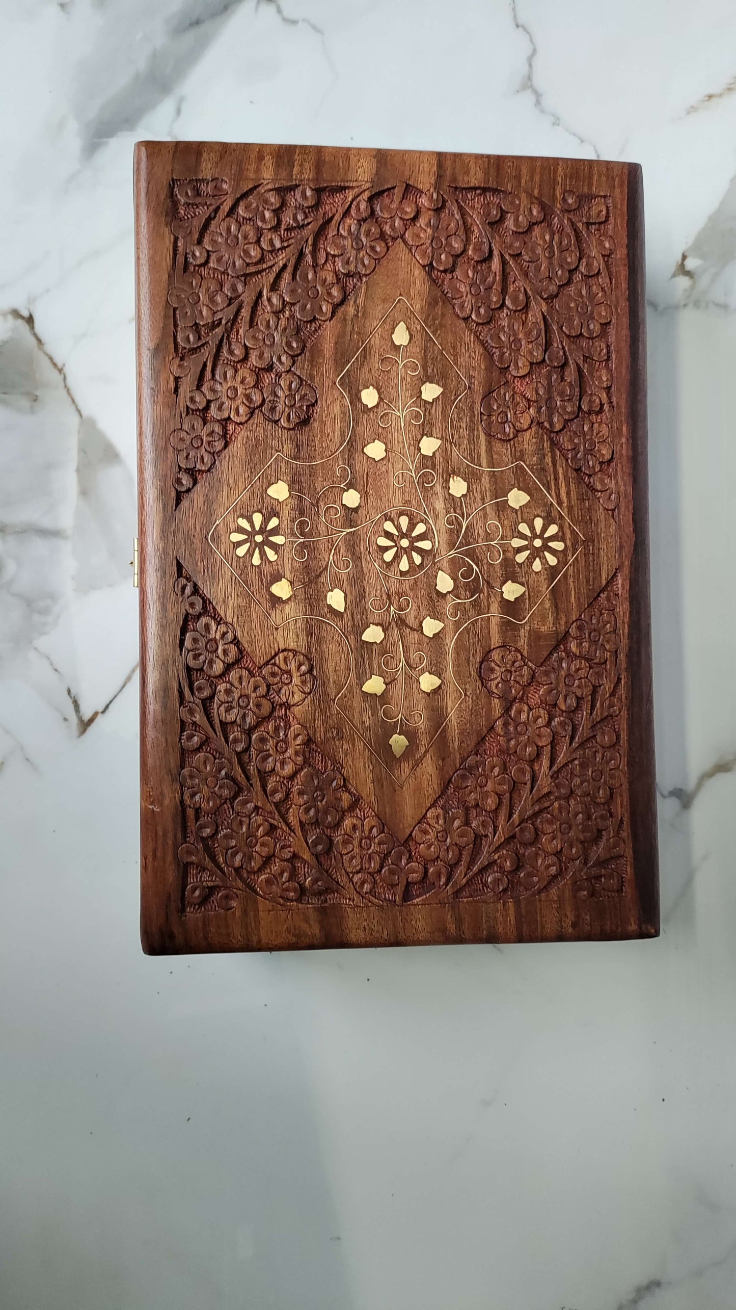 Front view of rectangular wooden jewellery box with brass corner accents and latch.