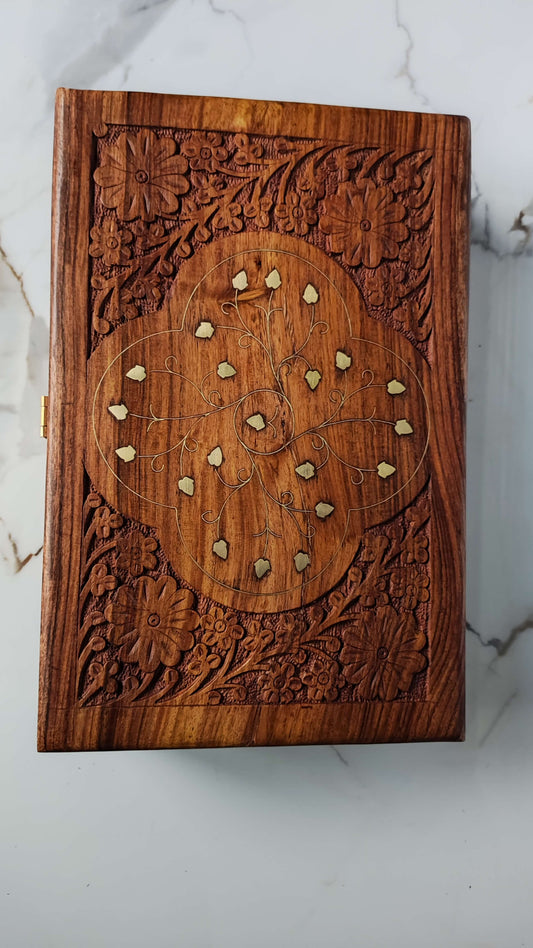 Front view of rectangular wooden jewellery box with brass corner accents and latch.