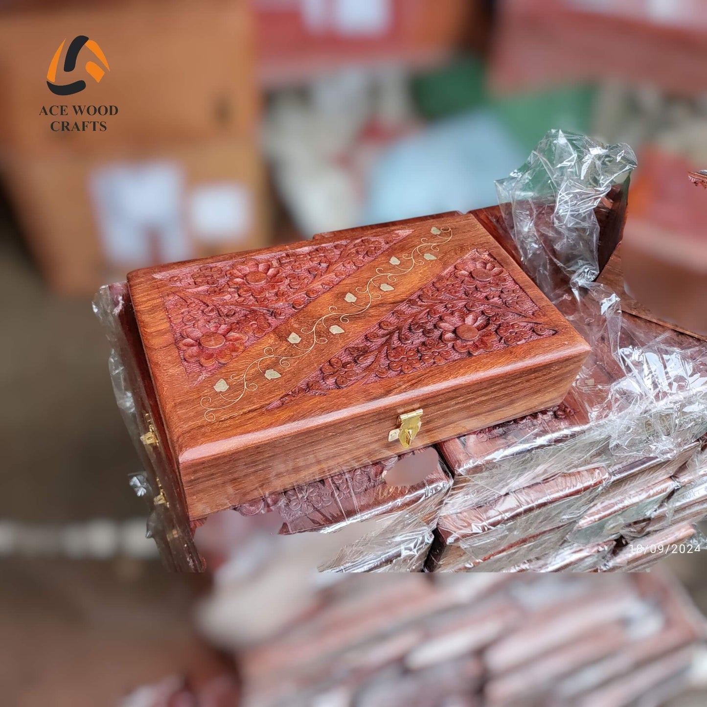 Angled view of hand-carved Sheesham wood jewellery box with floral brass inlay.