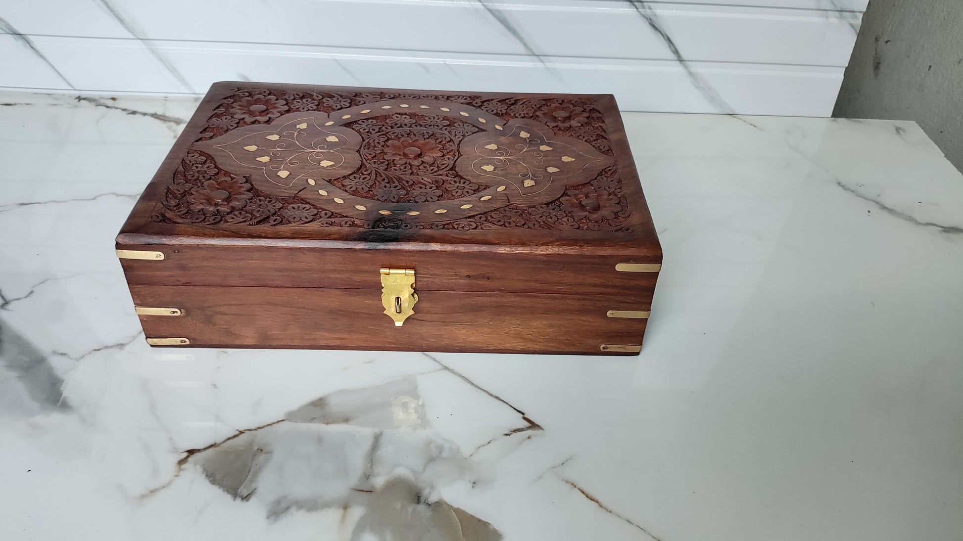 Angled view of rectangular wooden box featuring a unique X-shaped brass inlay design.