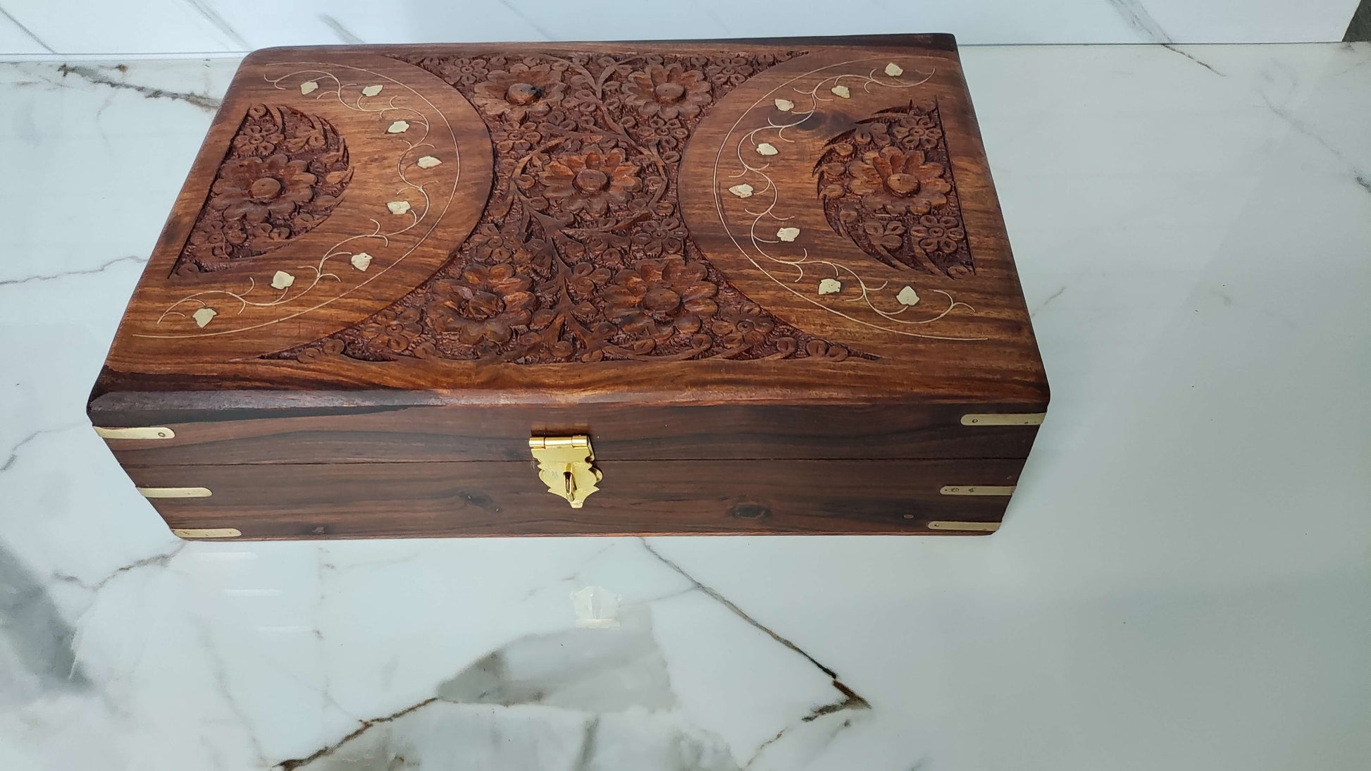 Angled view of rectangular wooden box featuring a unique X-shaped brass inlay design.