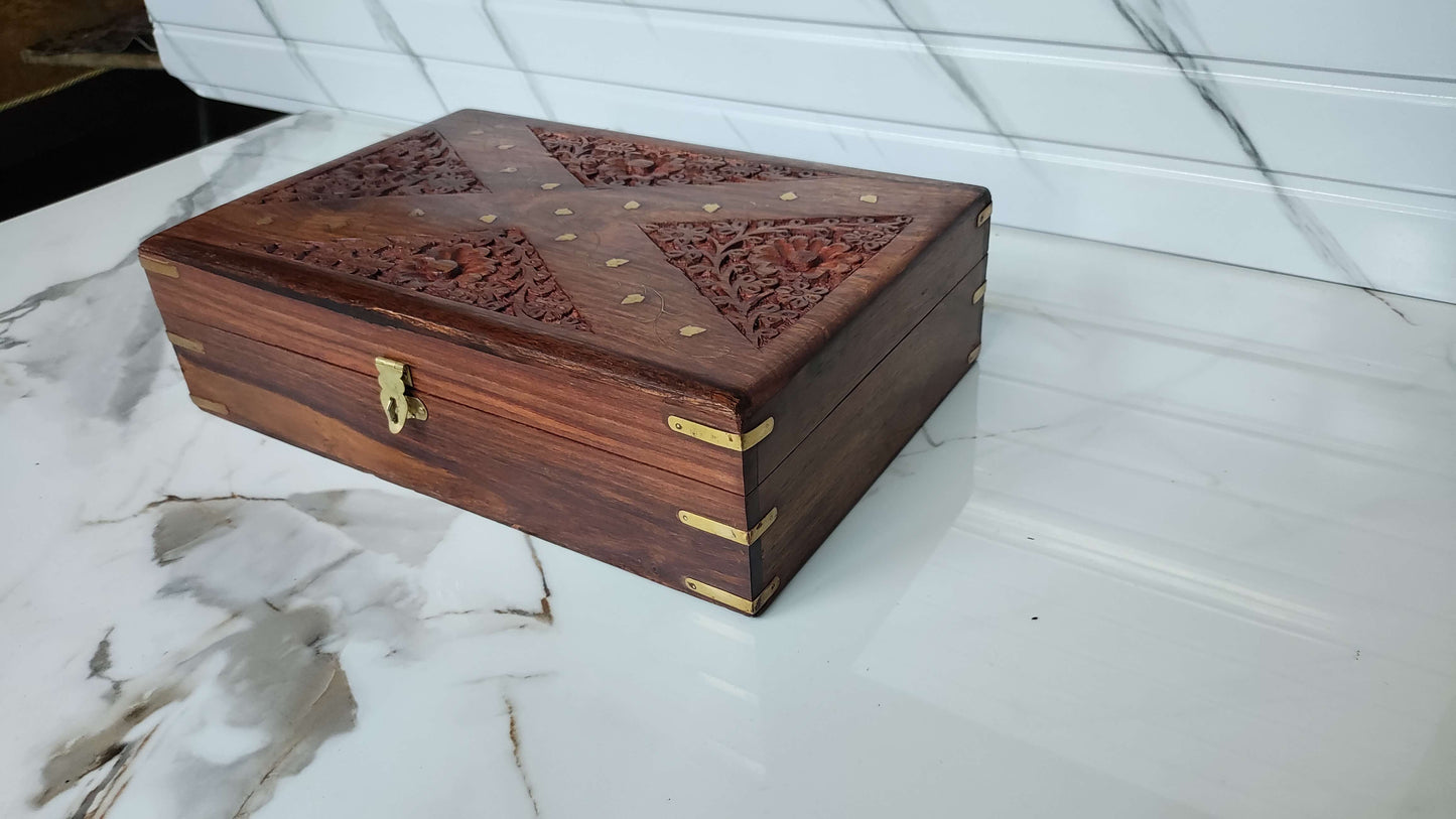 Angled view of handcrafted wooden jewellery box showing diamond pattern carving and brass corners.